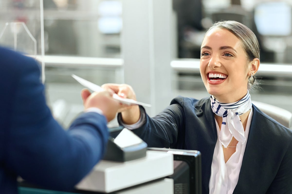 Airline company worker handing a boarding pass to a customer