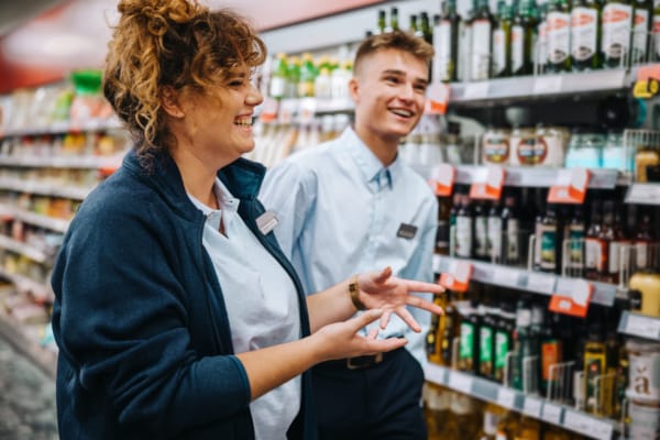 Two supermarket workers smiling