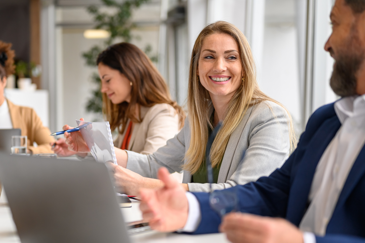 Professional colleagues smiling and discussing project details while working together in meeting room