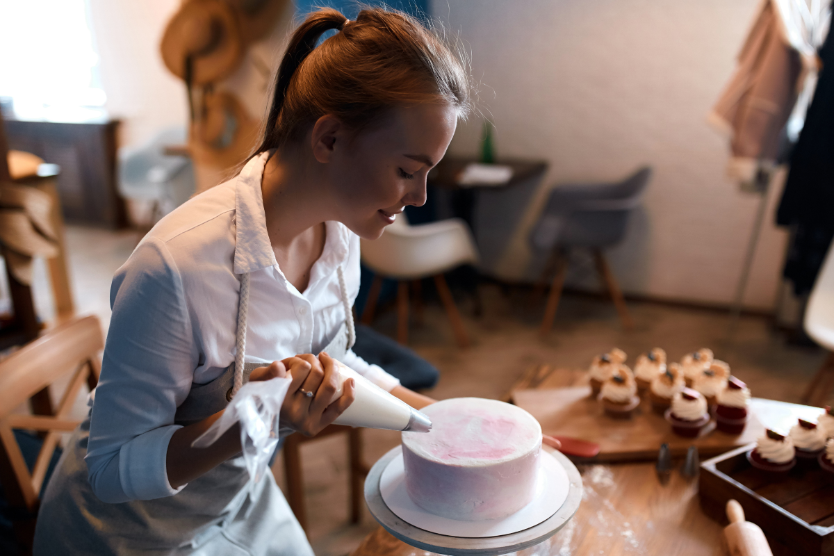 woman piping a cake for a competition