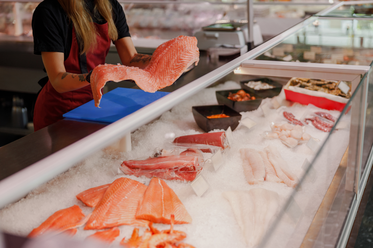 A vibrant and diverse assortment of fresh fish and seafood displayed on ice at a bustling local market