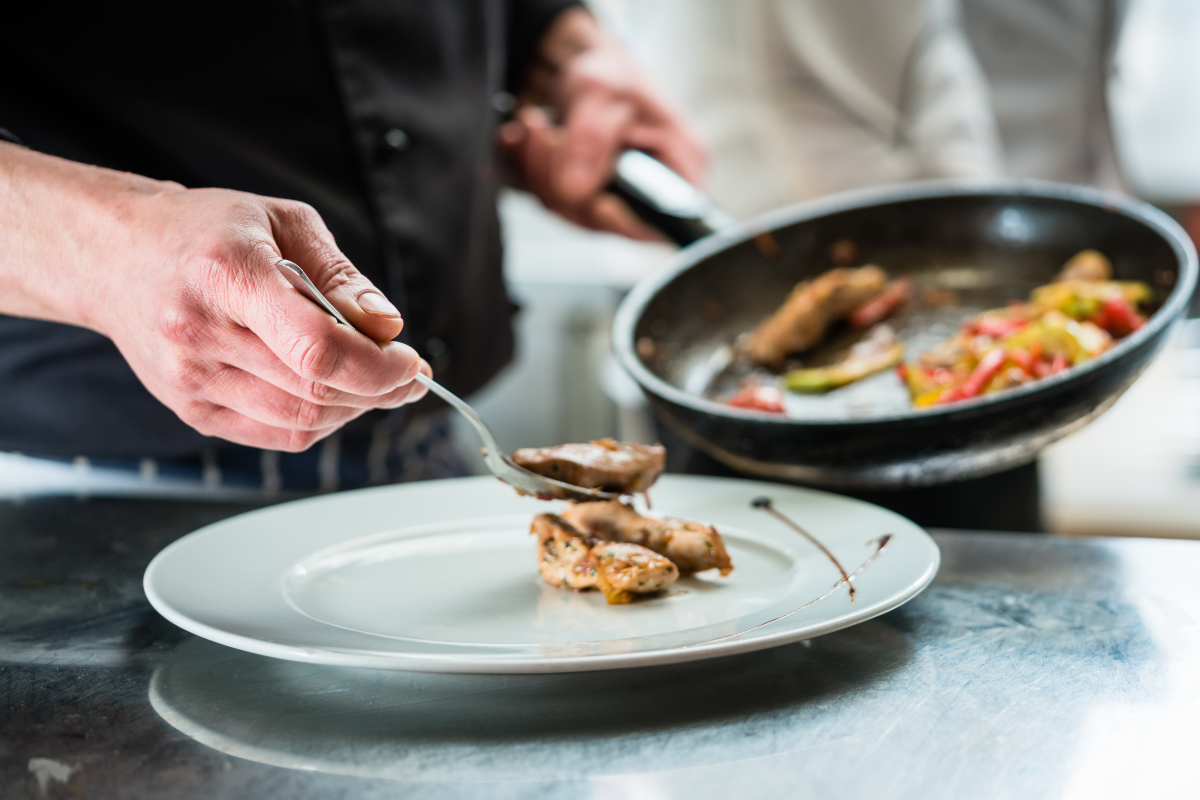 Chef finishing food on plate in restaurant
